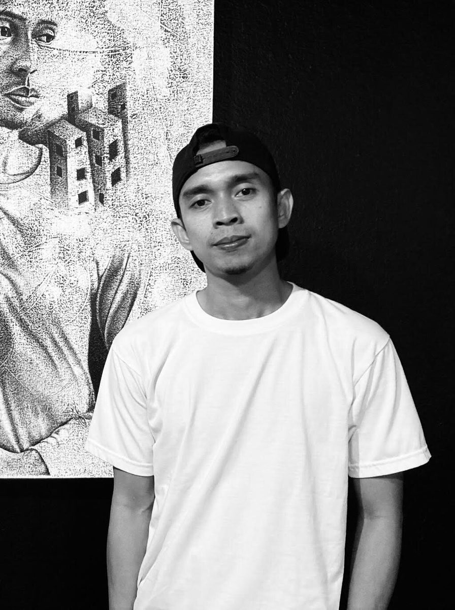 Jonathan Madeja standing before one of his stippled works